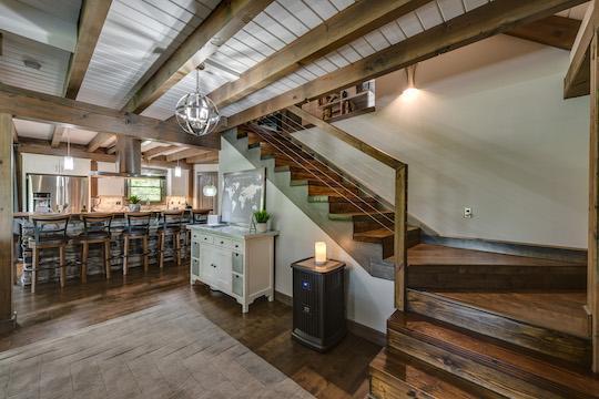 Photo of stairway and kitchen in open floor plan Epps plan with painted white wood ceiling and dark hardwood floors and open staircase to the loft area